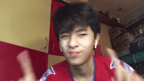 A Young Man Wearing Headphones Is Giving A Thumbs Up . GIF
