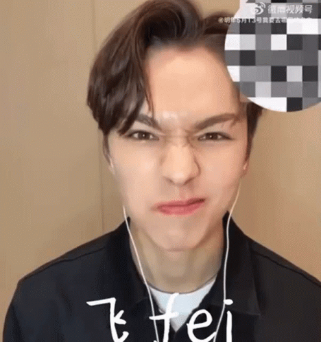 A Young Man Wearing Headphones Is Making A Face . GIF