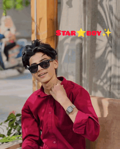 A Young Man Wearing Sunglasses And A Red Shirt Is Sitting In Front Of A Window With The Words Star Boy Above Him GIF