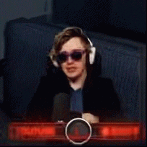 A Young Man Wearing Sunglasses And Headphones Is Sitting In Front Of A Youtube Sign GIF