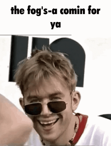 A Young Man Wearing Sunglasses Is Smiling And Laughing . GIF