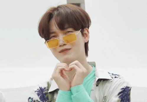 A Young Man Wearing Yellow Sunglasses Makes A Heart Shape With His Hands GIF