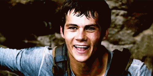 A Young Man With A Backpack Is Smiling And Looking At The Camera GIF