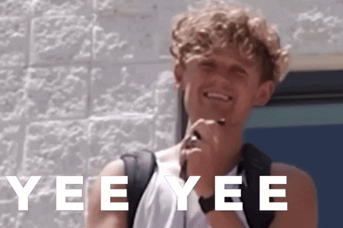 a young man with a backpack is smiling in front of a brick wall with yee yee written in white letters