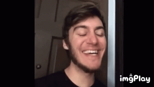 A Young Man With A Beard Is Smiling With His Eyes Closed And His Mouth Open . GIF