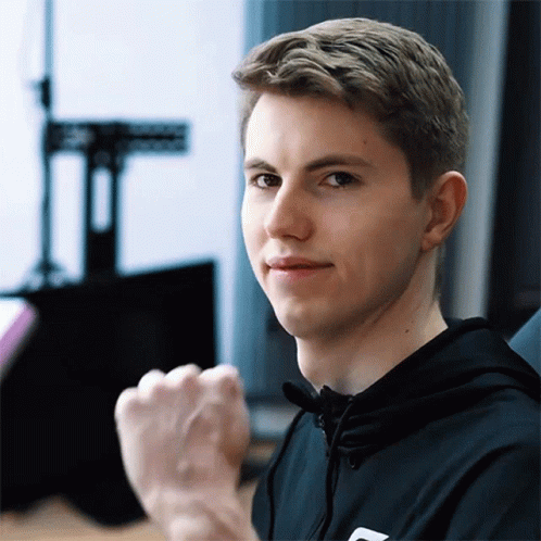 A Young Man With A Fist In The Air Is Wearing A Black Hoodie GIF