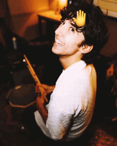 A Young Man With A Hand On His Head Playing Drums GIF