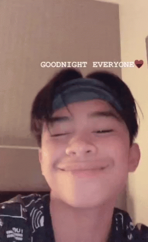 A Young Man With A Headband On His Head Is Smiling And Saying Goodnight Everyone . GIF