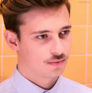 A Young Man With A Mustache Is Making A Funny Face . GIF