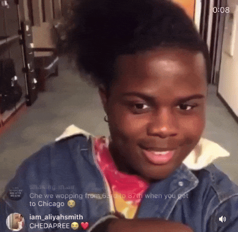 A Young Man With A Ponytail Is Smiling And Looking At The Camera With The Time Of 0:08 Behind Him GIF