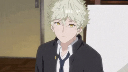 A Young Man With Blonde Hair And A Black Jacket And Tie GIF