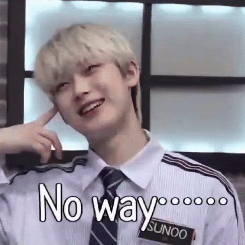A Young Man With Blonde Hair And A Tie Is Smiling And Making A Funny Face With His Finger In His Ear . GIF