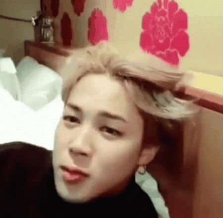 A Young Man With Blonde Hair Is Laying On A Bed With His Hair Blowing In The Wind . GIF