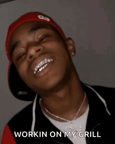 A Young Man With Braces On His Teeth Is Smiling With His Eyes Closed And Says `` Workin On My Grill '' . GIF