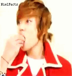 A Young Man With Brown Hair Is Wearing A Red Jacket And Eating Something . GIF