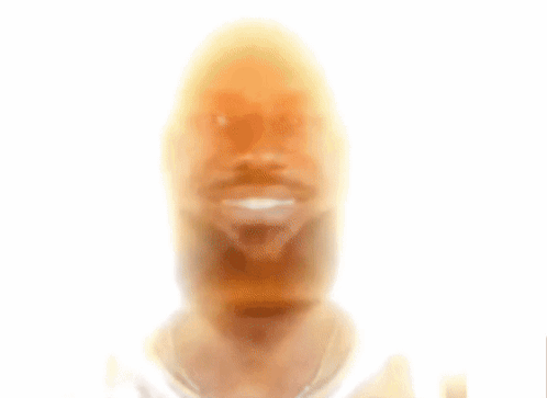 A Young Man With Curly Hair And A Beard Smiles GIF