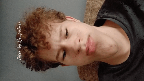 a young man with curly hair is laying on a couch with the words filter by kic palmer written on the bottom