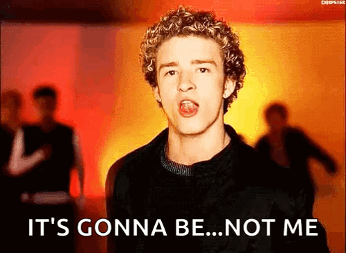 A Young Man With Curly Hair Is Singing In Front Of A Crowd . GIF