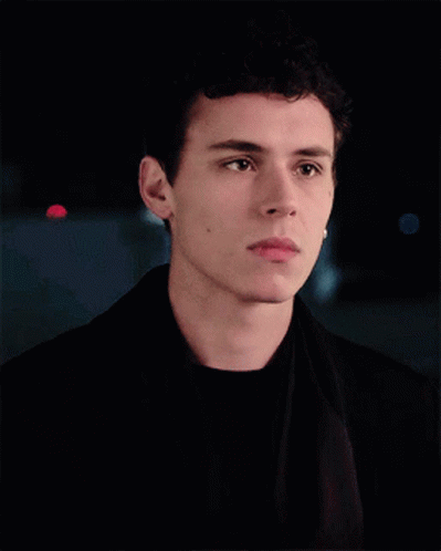A Young Man With Curly Hair Is Wearing A Black Jacket GIF