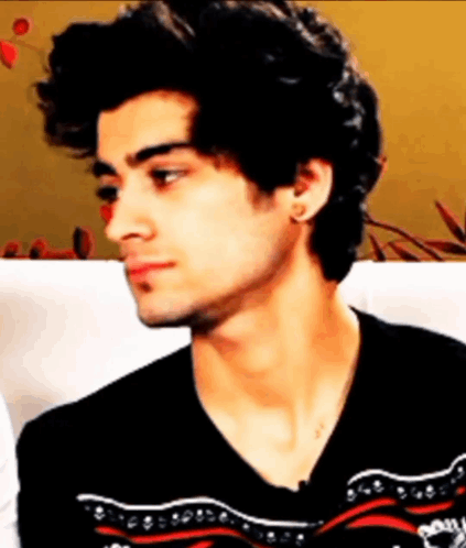 A Young Man With Curly Hair Is Wearing A Black Sweater GIF