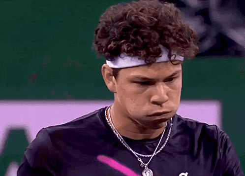 A Young Man With Curly Hair Wearing A Headband And A Necklace GIF