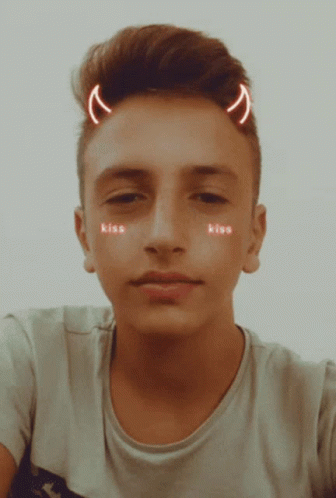 A Young Man With Devil Horns On His Head Has The Word Kiss On His Face GIF
