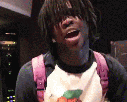 A Young Man With Dreadlocks Is Wearing A Pink Backpack And A White Shirt GIF