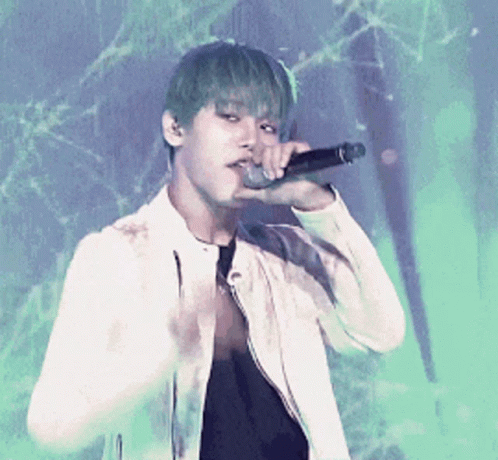 A Young Man With Green Hair Is Singing Into A Microphone While Wearing A White Jacket GIF