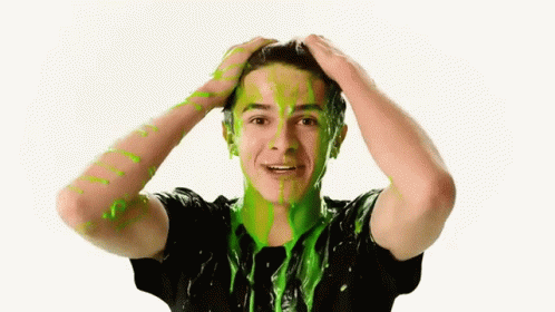 A Young Man With Green Slime On His Face Is Holding His Head GIF