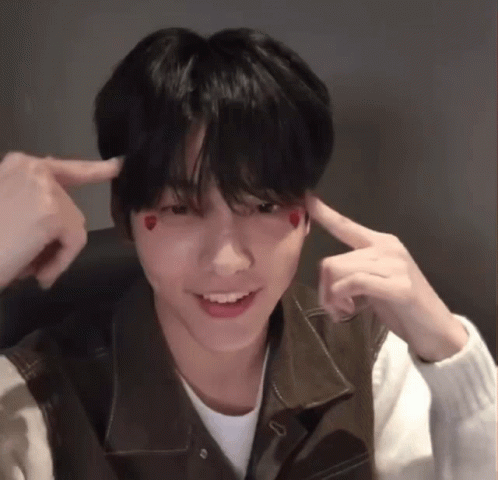 A Young Man With Hearts On His Face Is Making A Funny Face With His Fingers . GIF