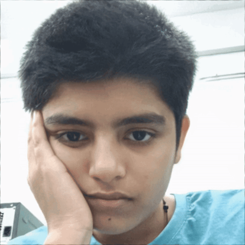 A Young Man With His Hand On His Face Is Wearing A Blue T-Shirt That Says ' At & T ' On It GIF