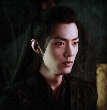 A Young Man With Long Black Hair And A Red Bow In His Hair GIF
