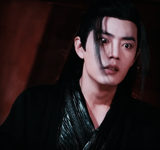 A Young Man With Long Black Hair Is Wearing A Black Shirt GIF