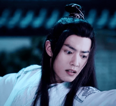 A Young Man With Long Black Hair Is Wearing A White Shirt And A Ponytail . GIF