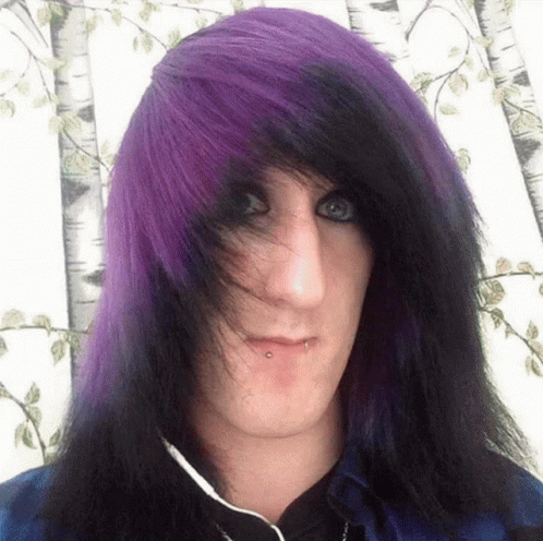 A Young Man With Purple And Black Hair Is Wearing Headphones GIF