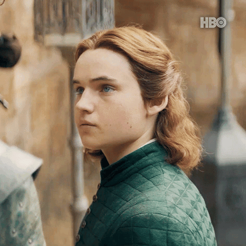 A Young Man With Red Hair And Blue Eyes Is Wearing A Green Jacket GIF