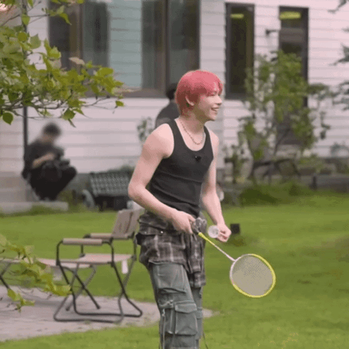A Young Man With Red Hair Is Holding A Badminton Racquet GIF