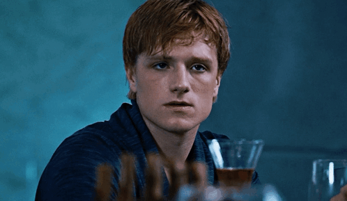 A Young Man With Red Hair Is Holding A Glass Of Wine GIF