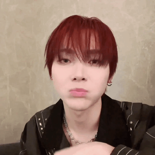 A Young Man With Red Hair Is Making A Funny Face While Wearing A Necklace And Earrings . GIF