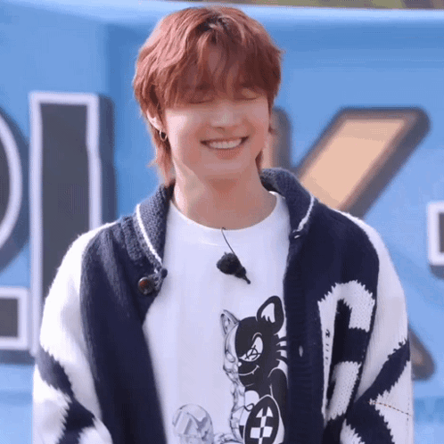 A Young Man With Red Hair Is Wearing A Sweater And A T-Shirt And Smiling . GIF