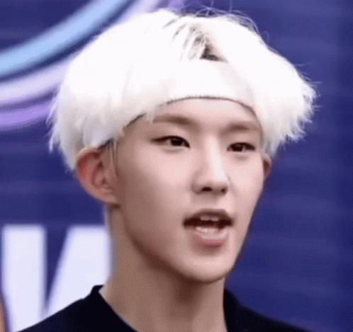 A Young Man With White Hair And A Headband On His Head Is Making A Funny Face . GIF