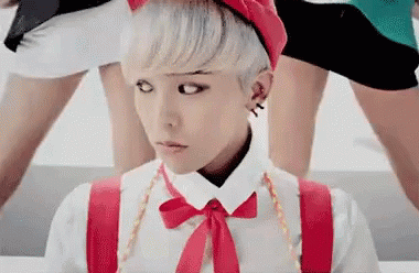 A Young Man With White Hair And A Red Hat Is Wearing Suspenders And A Bow Tie . GIF