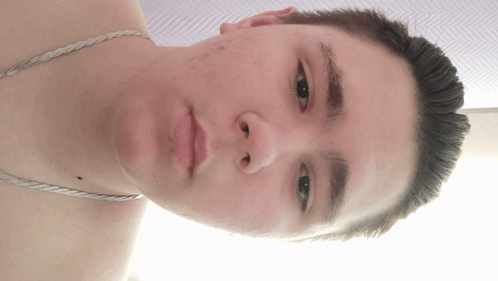 A Young Man Without A Shirt Is Looking At The Camera GIF