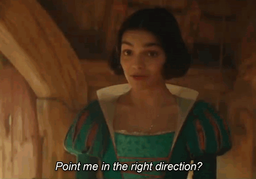 A Young Woman In A Green Dress Is Standing In A Room And Smiling . GIF
