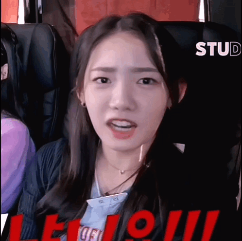 A Young Woman Is Sitting In A Roller Coaster Looking At The Camera . GIF