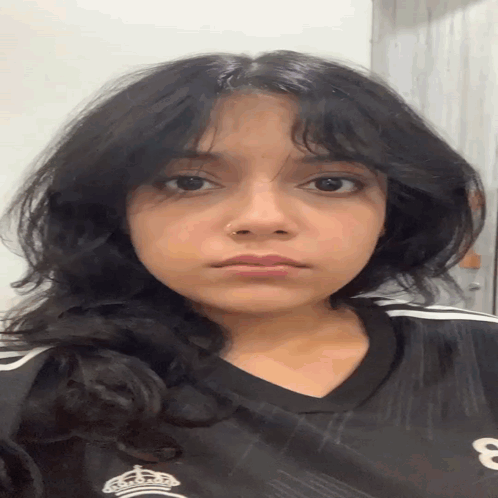 A Young Woman Wearing A Black Shirt With The Number 8 On It GIF