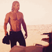 Actor Chris Hemsworth Walking Holding Shirt GIF