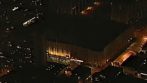 Aerial Night City With Large Lit Building