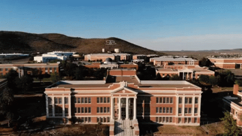 Aerial View of Brick Building With Mountain and Letter S