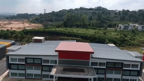 Aerial View of Large Building With Red and Black Roof